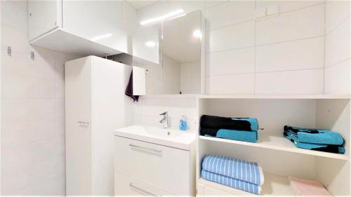 a white bathroom with a sink and a mirror at Pirjola in Seinäjoki