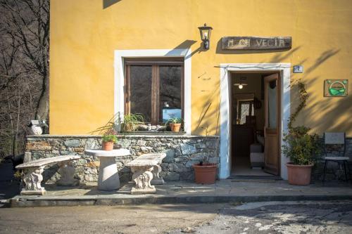 a yellow building with a bench in front of it at Agriturismo A Cà Vegia in Calice Ligure