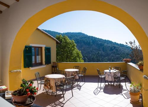 a patio with tables and chairs on a balcony at Agriturismo A Cà Vegia in Calice Ligure