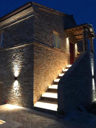 a stone house with stairs leading up to a building at Villa Angela Country House in Fermo
