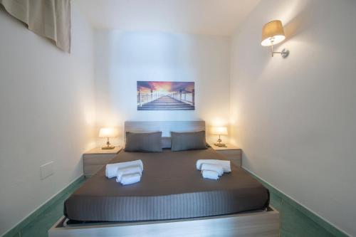 a bedroom with a large bed with two white chairs at Harmony in Amalfi