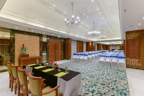 a banquet hall with tables and chairs and chandeliers at Lemon Tree Premier “The Atrium” Ahmedabad in Ahmedabad