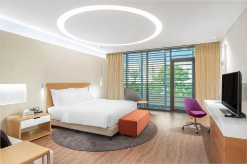 a hotel room with a bed and a tv at Radisson Blu Hotel & Residence, Riyadh Diplomatic Quarter in Riyadh