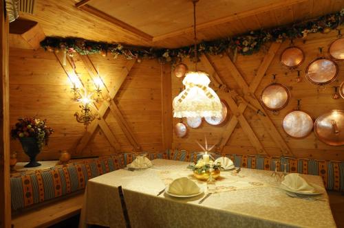 a dining room with a table and a chandelier at Sporthotel Europa Sul Lago in Alleghe