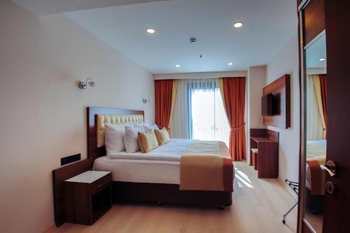 a hotel room with a large bed with a window at Hotel Paris Prestige in Izmir