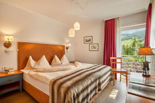 um quarto com uma cama grande e uma janela em Appartamenti La Sajun & Les Viles em La Villa