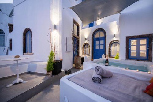 Habitación blanca grande con bañera y cama en Santo Blue Horizon Blue domes view, en Oia