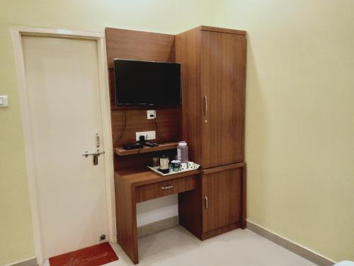 a room with a wooden cabinet with a television on it at RK appartment 3 bedroom with kitchen and balcony in Varanasi