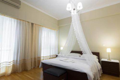 um quarto com uma cama e uma rede mosquiteira em Classy 2 bedroom apartment near Acropolis & Metro em Atenas