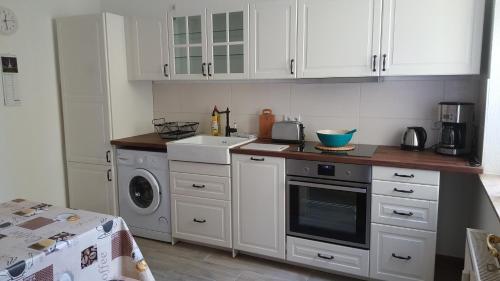 a kitchen with white cabinets and a washing machine at Fewo Am Marktplatz I in Eisenhüttenstadt