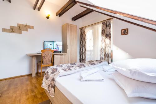 a bedroom with a bed and a desk at Pensiunea Dor de munte in Bran