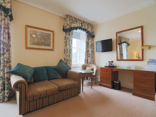 a living room with a couch and a desk and a mirror at Royal Hotel in Stornoway