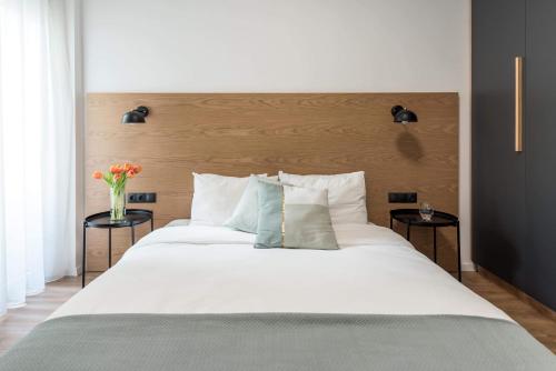 um quarto com uma grande cama branca e duas mesas em Central C&P Minimal Apartment em Tessalônica