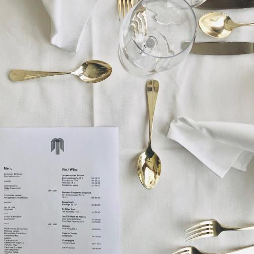a table with silverware and a menu and a spoon at Hotel Regina Terme in Leukerbad