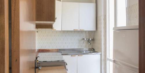 eine kleine Küche mit weißen Schränken und einem Kühlschrank in der Unterkunft M161 - Marcelli, ampio quadrilocale a due passi dal mare in Marcelli