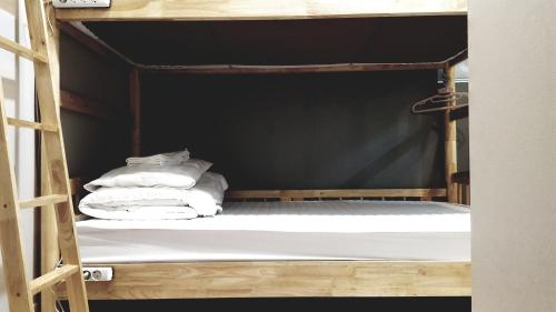 a bunk bed with white sheets and pillows on it at O'guest in Haeundae in Busan