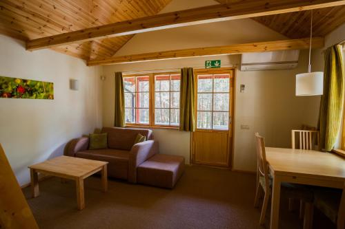 a living room with a couch and a table at Roosta Holiday Village in Elbiku
