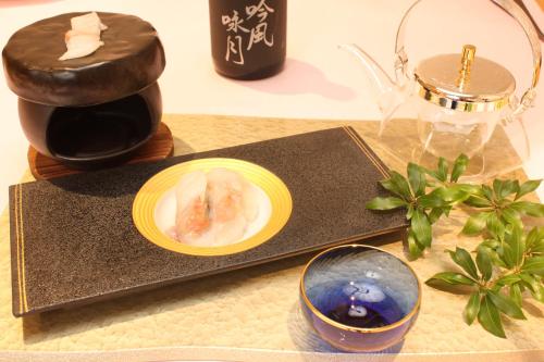 a table with a candle and a plate of food at 宮島離れの宿 IBUKU -Miyajima Hanare no Yado IBUKU- in Miyajima