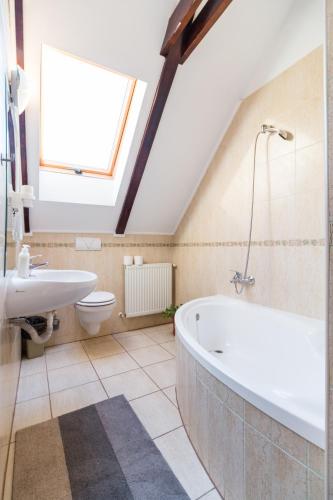 a bathroom with a white bath tub and a sink at Pensiunea Dor de munte in Bran