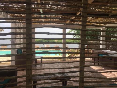a view of a swimming pool through a window at Les Barracudas in Sokone