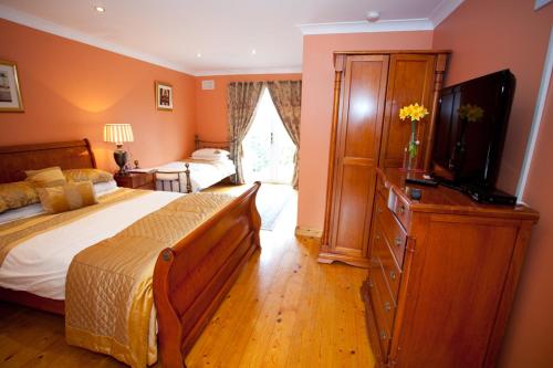 a bedroom with a bed and a dresser with a television at Evergreen Bed & Breakfast in Swords