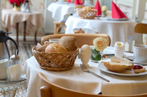 a table with a basket of bread and eggs on it at Pension am Dom in Erfurt