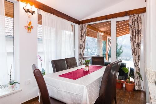 a dining room with a table and chairs and windows at Pensiunea Dor de munte in Bran