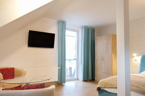 een kamer met een bed, een tafel en een raam bij Pension am Dom in Erfurt