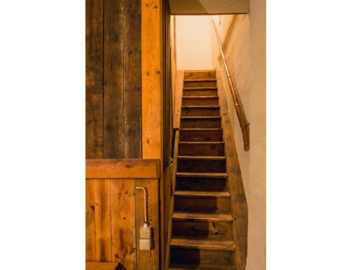 a staircase in a room with wooden walls at Wohnen im Denkmal in Gumperda