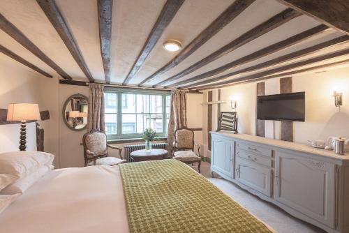 1 dormitorio con 1 cama y TV en la pared en The Standard Inn en Rye