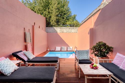 a backyard with a swimming pool and a deck with chairs at VIVA Casa da Praça with heated Pool and Terrace in Porto