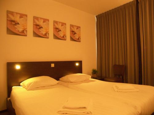 a bedroom with a bed with white sheets and pillows at Hotel de Markt in Valkenswaard