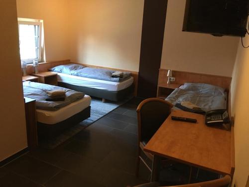 Cette petite chambre comprend deux lits et une table. dans l'établissement ANNO Brechtorf, à Brechtorf