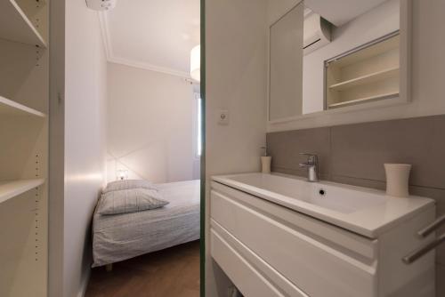 ein Badezimmer mit einem Waschbecken und ein Schlafzimmer mit einem Bett in der Unterkunft F3 Plein centre plage à 50 m (rue calme) parking possible in Saint-Raphaël