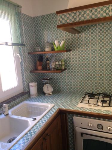 a kitchen with a sink and a stove at LA CASETTA DI ERIKA in Lacco Ameno
