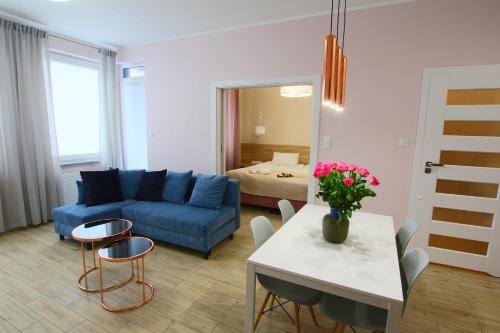 un soggiorno con divano blu e tavolo di Apartamenty Chwytowo 14 a Bydgoszcz