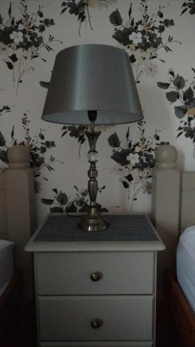 a lamp on a dresser in a bedroom with flowers at Midtown Farm Bed & Breakfast in Easton