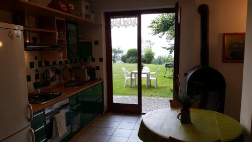 a kitchen with a door open to a yard with a table at Poggio San Fermo in Omegna