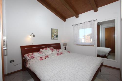 una camera con letto, finestra e specchio di Apartment Ala a Rovigno (Rovinj)