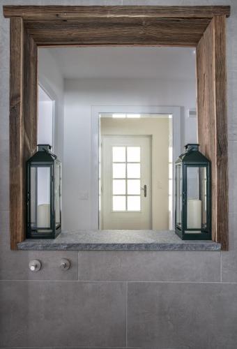 a mirror with two lights on top of a bathroom at Chalet Josianne in Saas-Fee