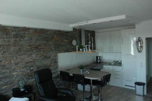 a kitchen with a table and chairs and a brick wall at Kiel - Schilksee Ferienwohnung Kasing inkl WLAN bezogene Betten und Handtücher in Schilksee