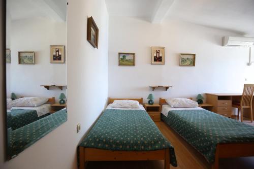 um quarto com duas camas e um espelho em Apartment and rooms Roko em Zaglav