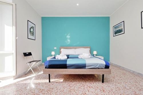ein blaues Schlafzimmer mit einem Bett und einem Stuhl in der Unterkunft WATERCOLOURS NEAR ST PETER in Rom