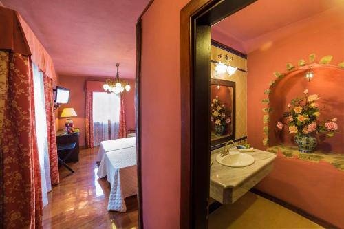 a bathroom with a sink and a bed in a room at Hotel Emblemático San Marcos in Icod de los Vinos