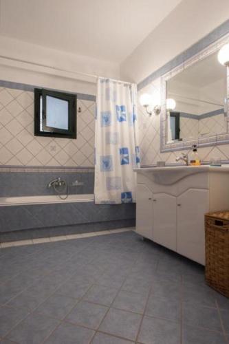 a bathroom with a sink and a shower and a mirror at Villa Giovanni in Paralia Vrachou