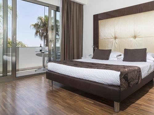 - une chambre avec un grand lit et un balcon dans l'établissement Hotel La Bussola, à Milazzo