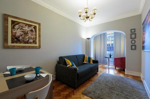 een woonkamer met een bank en een tafel bij My Saldanha Suites in Lissabon
