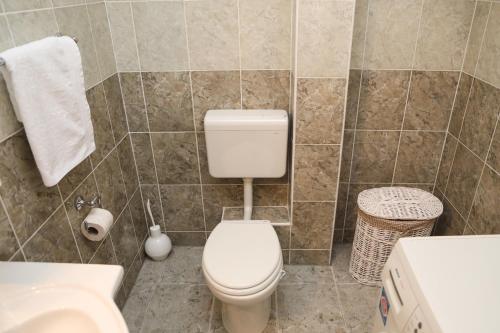 a bathroom with a toilet and a sink at Apartman Aurora in Solde