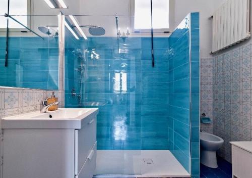 a bathroom with a sink and a shower with blue tiles at La Casa di Julia in Lecce
