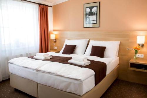 a hotel room with a large bed with white pillows at Hotel Karlin in Prague